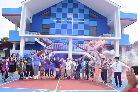 Kelompok peserta kegiatan berfoto di depan bangunan biru