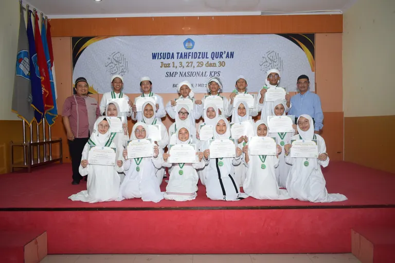 Siswa berbusana putih berfoto bersama di panggung acara wisuda tahfidz
