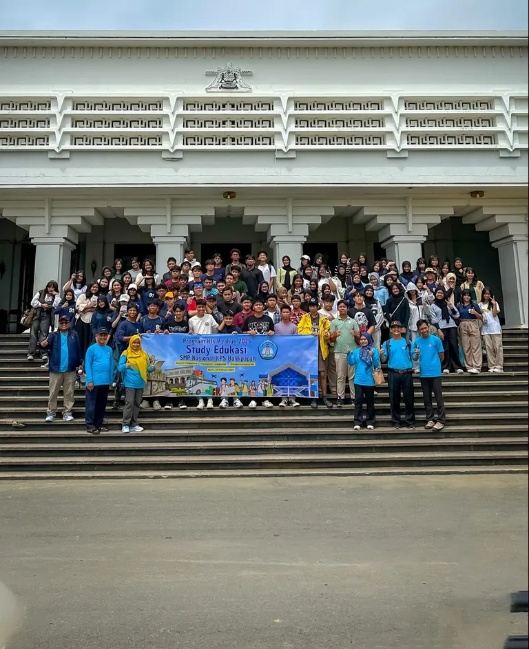 Rombongan siswa berfoto di tangga lokasi kunjungan