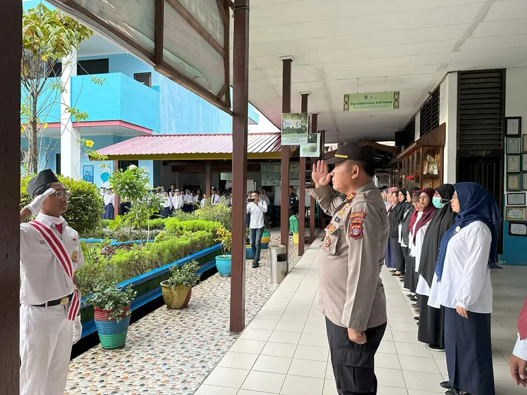 Petugas dan warga sekolah berdiri di koridor sekolah
