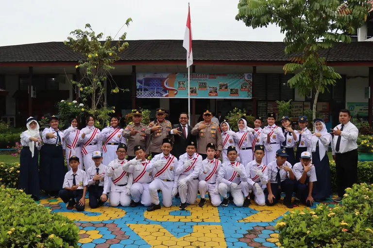 Siswa berseragam putih dan pendamping berfoto bersama di halaman sekolah